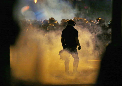 Police fire teargas as protestors converge on downtown following Tuesday's police shooting of Keith Lamont Scott in Charlotte, N.C., Wednesday, Sept. 21, 2016. Protesters have rushed police in riot gear at a downtown Charlotte hotel and officers have fired tear gas to disperse the crowd. At least one person was injured in the confrontation, though it wasn't immediately clear how. Firefighters rushed in to pull the man to a waiting ambulance.AP Photo