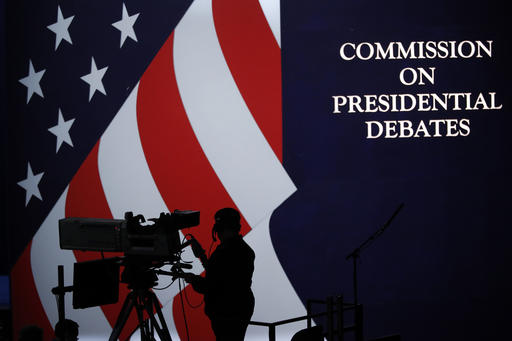 A cameraman is silhouetted against an an American flag during preparations for the presidential debate at Hofstra University in Hempstead, NY, Sunday, Sept. 25, 2016. (AP Photo/Mary Altaffer)