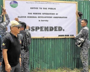 DENR officials post a notice of suspension of operations on the gates of Claver Mineral Development Corp., a company owned by Rep. Prospero Pichay. While the operations have been suspended, Pichay’s company was allowed to transport and sell P12 million worth of ore.         DANILO ADORADOR/INQUIRER MINDANAO