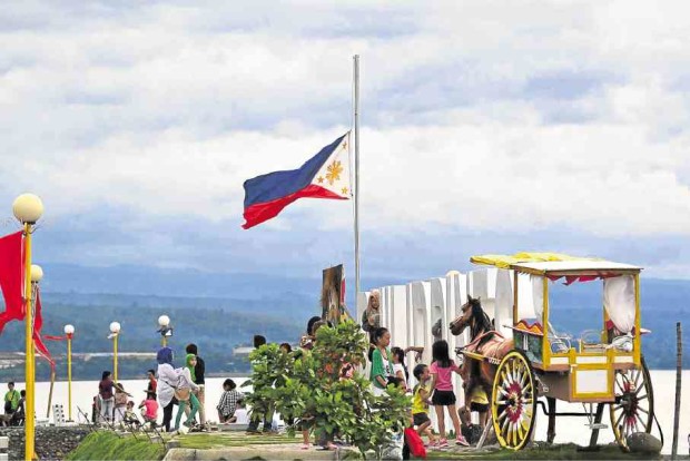 IN MEMORY OF MIRIAM The Philippine flag flies at half-staff in Iligan City’s Paseo de Santiago park, lending a sad note to the otherwise festive air as the city celebrates the feast of St. Michael and the Archangels on Thursday. The lowering of the flag to half-staff marks the passing of Sen. Miriam Defensor Santiago early Thursday morning after losing a battle with lung cancer. RAFAEL C. ROMERO/CONTRIBUTOR