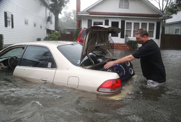 ST AUGUSTINE, FL - OCTOBER 07: Rob Birch salvages a speaker from the trunk of his car which floated out of his drive way as Hurricane Matthew passes through the area on October 7, 2016 in St Augustine, Florida. Florida, Georgia, South Carolina and North Carolina all declared a state of emergency in anticipation of Hurricane Matthew.   Joe Raedle/Getty Images/AFP