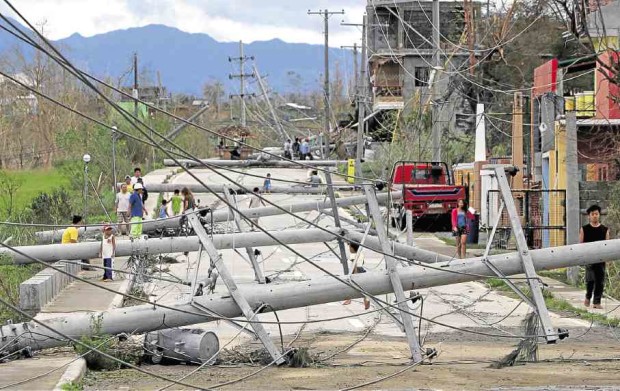 POWER LINES DOWN Electric posts toppled by Supertyphoon “Lawin” block Campos Street in Tuguegarao City, Cagayan province. Even so, authorities reported a low death toll after the typhoon barreled through northern Luzon. —RICHARD A. REYES