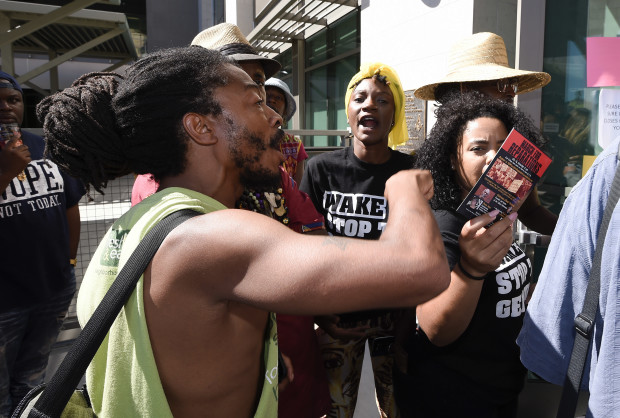 Protesters yell at police officers in front of the El Cajon Police Department headquarters before a news conference on Friday Sept. 30, 2016, in San Diego, Calif., held to address the killing of Alfred Olango, a Ugandan refugee shot by an El Cajon police officer on Tuesday.  The El Cajon police department released video footage of the shooting at the news conference. (AP Photo/Denis Poroy)