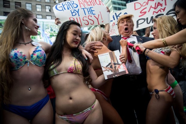 NEW YORK, NY - OCTOBER 25: (EDITOR'S NOTE: Image contains profanity.) A Donald Trump look-a-like poses with bikini-clad women in Times Square, October 25, 2016 in New York City. The stunt was organized by artist Alison Jackson.   Drew Angerer/Getty Images/AFP