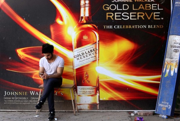An Iraqi man sits in front to a closed liquor store in Ainkawa, a majority Christian area in the Kurdish region of northern Iraq, on October 13, 2015.  / AFP PHOTO / SAFIN HAMED