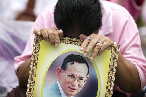 A woman prays for Thailand's King Bhumibol Adulyadej at Siriraj Hospital where the king is being treated in Bangkok, Thailand, Thursday, Oct. 13, 2016. Hundreds of tearful Thais continue to offer flowers and chant prayers for the king outside the Bangkok hospital where the world's longest-reigning monarch is being treated for multiple health problems. (AP Photo/Wason Wanichakorn)