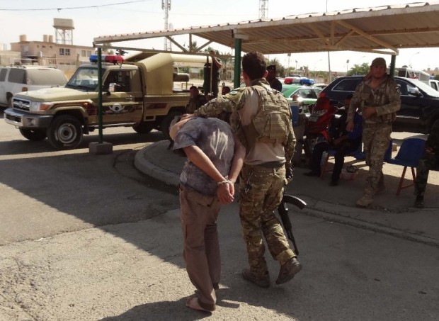 Iraqi Kurdish security forces escort a suspected member of the Islamic State group who got arrested the previous day during clashes in the southern suburbs of Kirkuk, on October 22, 2016. Security forces battled for a second day with Islamic State gunmen who infiltrated Kirkuk in a brazen raid that rattled Iraq as it ramped up an offensive to retake Mosul. A day after the shock attack on the Kurdish-controlled city, jihadist snipers and suspected suicide bombers were still at large, prompting Baghdad to send reinforcements.  / AFP PHOTO / Marwan IBRAHIM