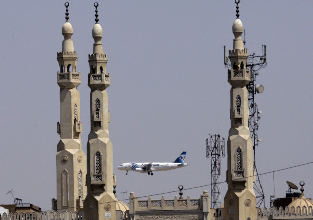 FILE - In this May 21, 2016 file photo, an EgyptAir plane flies past minarets of a mosque as it approaches Cairo International Airport, in Cairo, Egypt. Egyptian Aviation officials said on Sunday they would soon announce a tender for a new security system for Cairo airport employees involving retina scans, attempting to meet a key Russian condition to resume flights to Egypt.  (AP Photo/Amr Nabil, File)