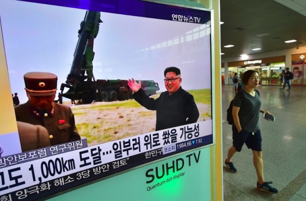 A woman walks past a television screen reporting news of North Korea's latest Musudan missile test, at a railway station in Seoul on June 23, 2016. North Korean leader Kim Jong-Un has hailed the successful test of a powerful new medium-range missile, saying it poses a direct threat to US military bases in the Pacific, state media reported on June 23. / AFP PHOTO / JUNG YEON-JE