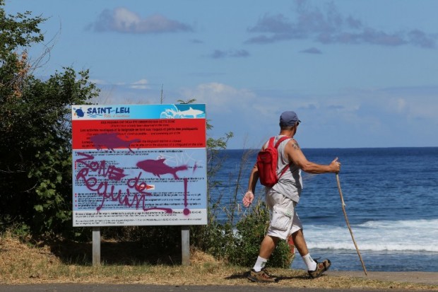 A graffiti reading "Shark's area" as been written on an information board, on April 14, 2015 off Saint-Leu, on the western coast of the French Indian Ocean island of La Reunion, two days after a 13-year-old boy was attacked and killed by a shark.  It was the 16th shark attack on the island since 2011 and the seventh loss of life.   AFP PHOTO / RICHARD BOUHET / AFP PHOTO / RICHARD BOUHET