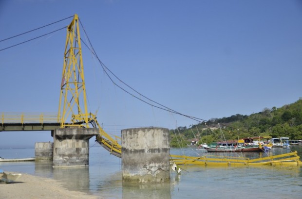 This picture taken on October 17, 2016 shows a bridge connecting two small islands southeast of Indonesian holiday hotspot Bali that collapsed on October 16, sending motorbikes flying into the water and leaving eight dead and about 30 injured. The suspension bridge linking Nusa Lembongan and Nusa Ceningan, two small islands popular with tourists southeast of Indonesian holiday hotspot Bali, collapsed at 6:30 pm (1030 GMT) on October 16, the country's disaster agency said. / AFP PHOTO / STR