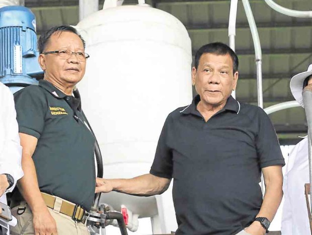 President Duterte and antinarcotics officials have their photos taken in front of pieces of equipment in an abandoned facility in Arayat town, Pampanga province which authorities said are capable of producing up to 400 kg of “shabu” every day. JOAN BONDOC