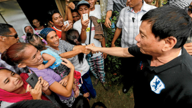 BASILAN VISITOR President Duterte meets villagers while on hisway to distribute farm equipment to members of Lamitan Agrarian Reform Beneficiaries Cooperative in Lamitan City in Basilan province on Monday. —MALACAÑANG PHOTO
