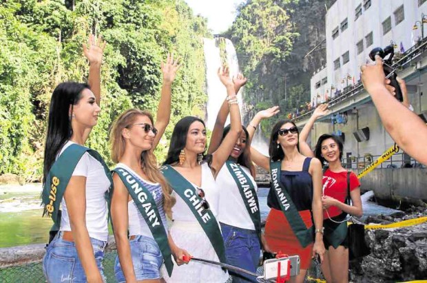 Candidates of the Miss Earth beauty pageant pose for photographers with the Maria Cristina Falls, a main tourist attraction in Iligan City but part of a hydropower facility, in the background. —RICHEL UMEL