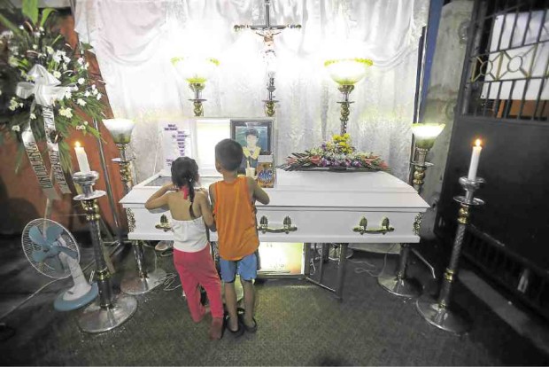 The children view his remains during the wake at the family residence. 
