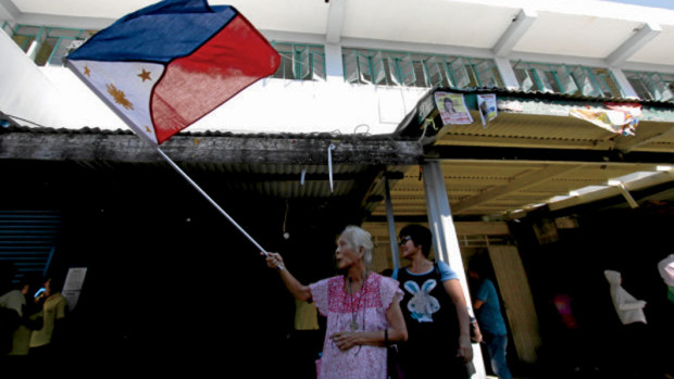 DUTERTE WELCOME A Tuguegarao woman welcomes President Duterte while waving the Philippine flag during his visit to typhoon-hit areas in Cagayan province on Sunday. —RICHARD A. REYES