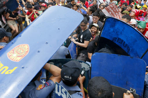 Police and protesters clash during a violent protest outside the U.S. Embassy in Manila, Philippines, Wednesday, Oct. 19, 2016. A Philippine police van rammed into protesters, leaving several bloodied, as an anti-U.S. rally turned violent Wednesday at the embassy in Manila. AP