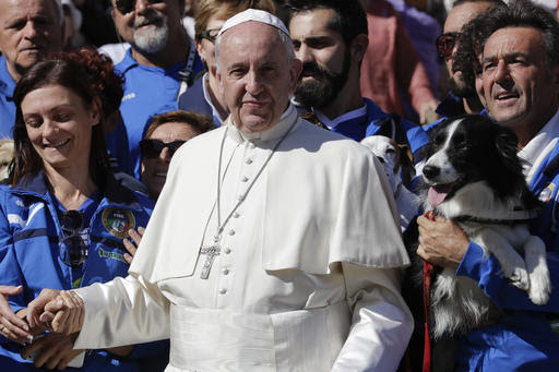 Pope Francis poses for photographers with a group of dog trainers, during  his weekly general audience, in St. Peter's Square, at the Vatican,  Wednesday, Oct. 5, 2016. (AP Photo/Andrew Medichini)