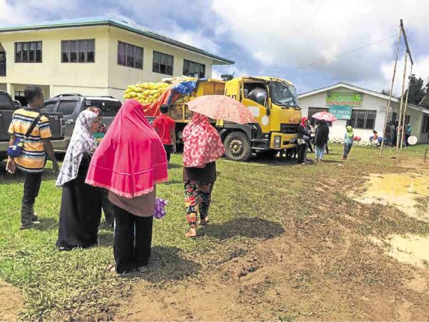 Some residents of Basilan province displaced by fighting in three towns walk toward a truck loaded with relief goods in this file photo taken in Tipo-tipo town in July.