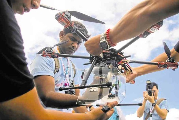 Participants load a can satellite into a drone during the first international Can Satellite Competition held at the University of  the Philippines Los Baños, Laguna. —KIMMY BARAOIDAN