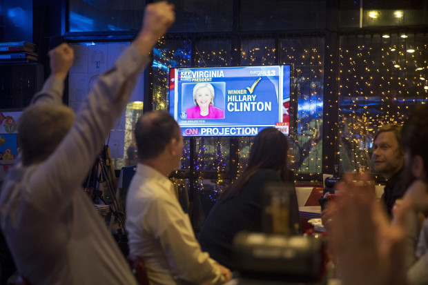 Andrew Hardisty of the U.S., left, and other people react as they watch a live telecast of the U.S. presidential election in a cafe in Moscow, Russia, Wednesday, Nov. 9, 2016. Around the world, people reacted with fears and cheers to news of the election of Donald Trump.  AP
