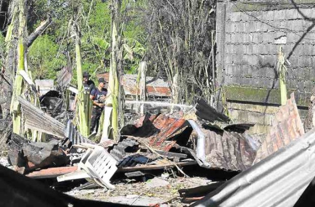 DEADLY BANG Policemen and firemen inspect the extent of damage to a firecracker manufacturing area in Sta. Maria town in Bulacan province after an explosion on Wednesday.  —JOAN BONDOC