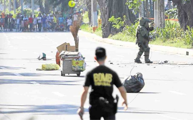 A bomb squad secures a section of Roxas Boulevard to retrieve an improvised explosive device (encircled) hurled from a taxicab early Monday. —PHOTOS BY MARIANNE BERMUDEZ