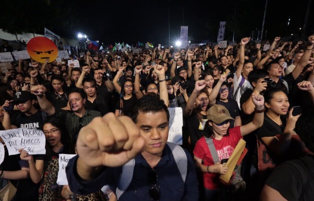 Anti-Marcos protesters raise their fists and sing Bayan Ko at the People Power Monument along Edsa on Nov. 30, 2016, to protest the burial of dictator Ferdinand Marcos at the Libingan ng mga Bayani. (PHOTO BY GRIG C. MONTEGRANDE/ INQUIRER)