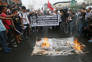 Protesters burn an effigy of the late President Ferdinand Marcos as part of a Black Friday protest on Friday, Nov. 25, 2016.