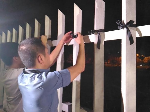 Members of the Block Marcos Group tie black ribbons around the railing of the gate to the Libingan ng mga Bayani on Nov. 29, 2016, to protest the hero's burial given to dictator Ferdinand Marcos. (PHOTO BY DEXTER CABALZA, INQUIRER)