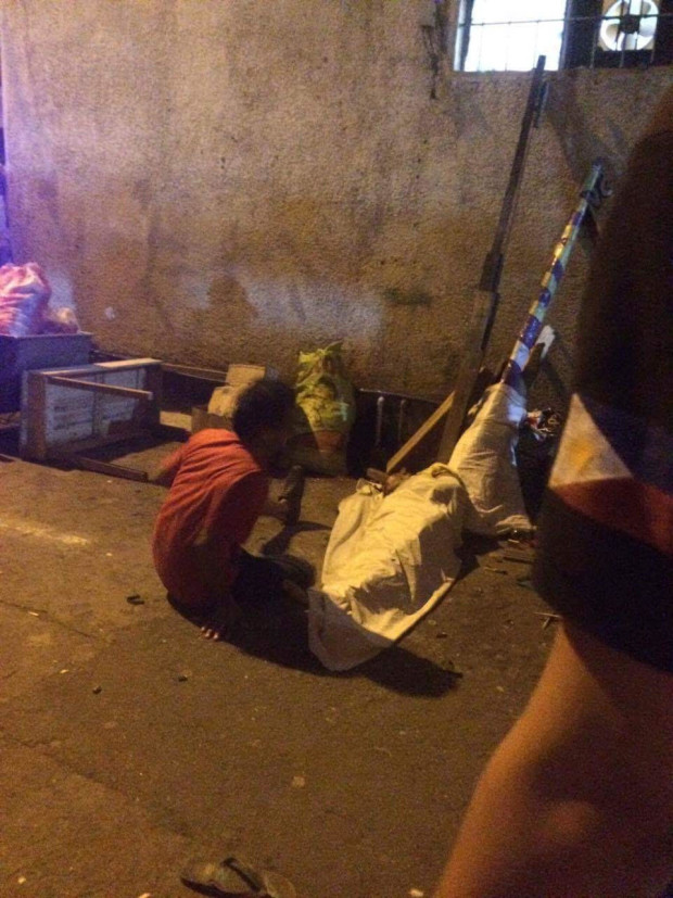 RUBOUT:  Adonis Sidayon covers with white cloth the body of his brother, Albert Sidayon,  a confessed drug user, who was shot dead by motorcycle-riding gunmen in Pasig City on the night of Nov. 28, 2016. (PHOTO BY ALLAN POLICARPIO/ INQUIRER)