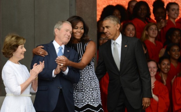 WASHINGTON, DC - SEPTEMBER 24: President Barack Obama watches first lady Michelle Obama embracing former president George Bush, accompanied by his wife, former first lady Laura Bush, while participating in the dedication of the National Museum of African American History and Culture September 24, 2016 in Washington, DC, before the museum opens to the public later that day. The museum is a Smithsonian Institution museum located on the National Mall featuring African American history and culture in the US.   Astrid Riecken/Getty Images/AFP
