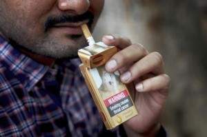 Indian takes cigarette from pack.