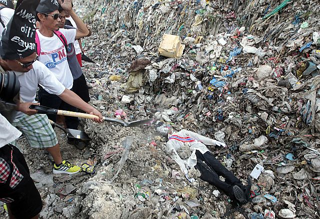 Cebu City activists bury the effigy of Ferdinand Marcos in a dumpsite, on Nov. 15, 2016, to protest the decision of President Rodrigo Duterte to order the burial of the dictator at the Libingan ng mga Bayani and the ruling of the Supreme Court upholding Duterte's order.  Among those who joined the protest action were Cebu City Mayor Tomas Osmeña and retired judge Mienrado Paredes who was imprisoned during Martial Law. (CDN/ TONEE DESPOJO)