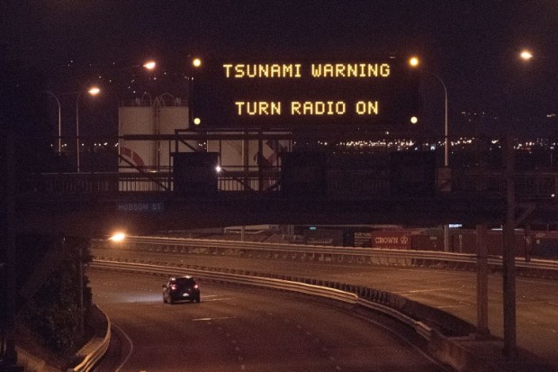 A tsunami warning alert is seen on a notice board above State Highway 1 in Wellington early on November 14, 2016 following an earthquake centred some 90 kilometres (57 miles) north of New Zealand's South Island city of Christchurch.  A powerful 7.8 magnitude earthquake rocked New Zealand early November 14, the US Geological Survey said, prompting a tsunami warning and knocking out power and phone services in many parts of the country.  / AFP PHOTO / Marty Melville