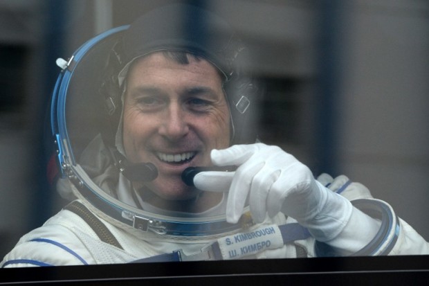 US astronaut Shane Kimbrough gestures from inside a bus as he leaves to board the Soyuz MS-02 spacecraft at the Russian-leased Baikonur cosmodrome on October 19, 2016. / AFP PHOTO / Vasily MAXIMOV