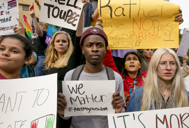 FILE - In this Thursday Nov. 10, 2016 file photo, from left, Celeste Ramirez, 20, Erin Ckodre , 21, Ronald Elliott, 18, Patricia Romo, 22, and Rose Ammons, 18, hold up signs during a rally at Texas State University in San Marcos, Texas, to protest Donald Trump's presidential election victory. For the combatants in America's long-running culture wars, the triumph of Trump and congressional Republicans was stunning _ sparking elation on one side, deep dismay on the other. (Jay Janner/Austin American-Statesman via AP)