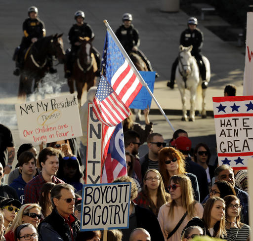 People protest against the election of President-elect Donald Trump Saturday, Nov. 12, 2016, in front of City Hall in Kansas City, Mo. Thousands took to the streets Saturday across the United States as demonstrations against Trump continued in New York, Chicago, Los Angeles and beyond. (AP Photo/Charlie Riedel)
