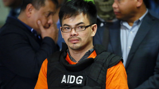 Alleged Filipino drug lord Kerwin Espinosa listens to a question as he is presented to the media upon arrival from Abu Dhabi early Friday, Nov. 18, 2016 at Camp Crame in suburban Quezon city, northeast of Manila, Philippines. Espinosa, whose father Mayor Rolando Espinosa was killed inside his detention cell, told a news conference he will "tell all" those involved in the illegal drug trade in the country.(AP Photo/Bullit Marquez)