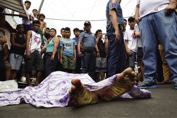 UNINTENDED TARGET   A man lies dead in the street in Port Area, Manila, after he and his four cohorts reportedly fired at policemen who were after somebody else.  —AFP