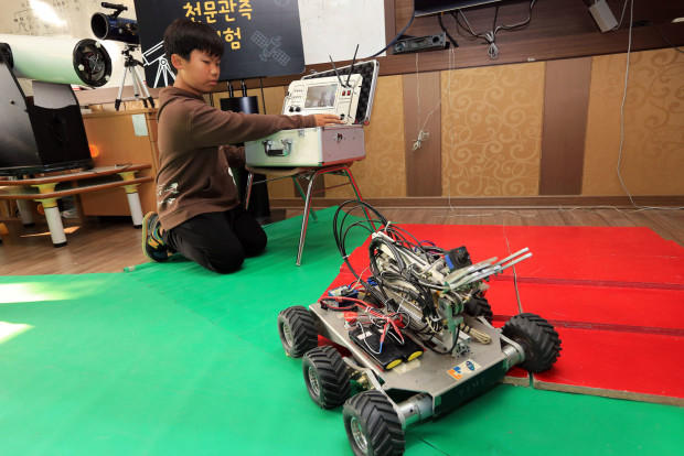 A student from Meewon Elementary School’s Jangrak branch learning how to control a robot on display. Photo by KIM JINHA//The Straits Times/Asia News Network