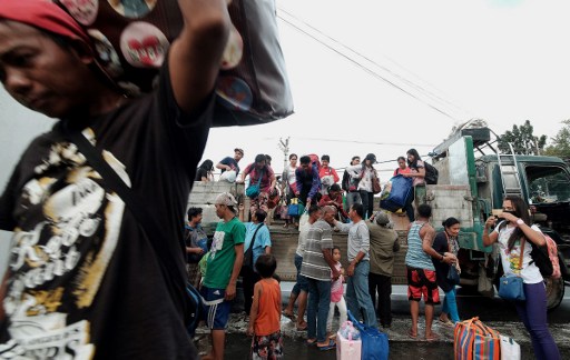 Stranded passengers from Tabaco port are evacuated by the local government in Tabaco City, Albay province on December 24, 2016 after their seafaring vessels were prohibited from sailing ahead of typhoon Nock-Ten's expected arrival.  Philippine authorities began evacuating thousands of people and shut down dozens of ports on December 24 as a strong typhoon threatened to wallop the country's east coast on Christmas Day. Nock-Ten is expected to be packing winds of between 203-250 kilometres per hour (126-155 miles per hour) when it crosses over Catanduanes, a remote island of 250,000 people in the Bicol region, late Sunday, the US Joint Typhoon Warning Center said.   / AFP PHOTO / Charism SAYAT