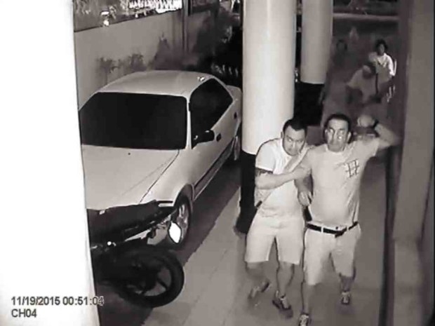 Melvin Odicta Jr. (left) and his late father, Melvin Sr., as shown in footage from a security camera of a radio station in Iloilo City.