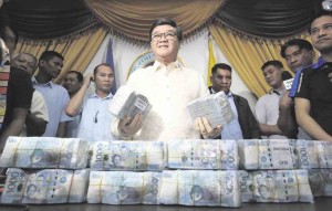 PAYOFF MONEY Justice Secretary Vitaliano Aguirre II shows the P30 million turned over by Associate Immigration Commissioners Al Argosino and Michael Robles. The two officials allegedly extorted the money from gaming tycoon Jack Lam in exchange for the release of illegal Chinese workers. —MARIANNE BERMUDEZ