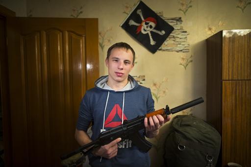 In this photo taken on Saturday, Oct. 29, 2016, Mikhail Galaktionov, 17, holds an airsoft rifle posing for a photo at his home in Pervouralsk, Yekaterinburg region, Russia. Increasingly, the young men of Russia say they see military service as an opportunity, not a dreaded obligation to avoid. AP