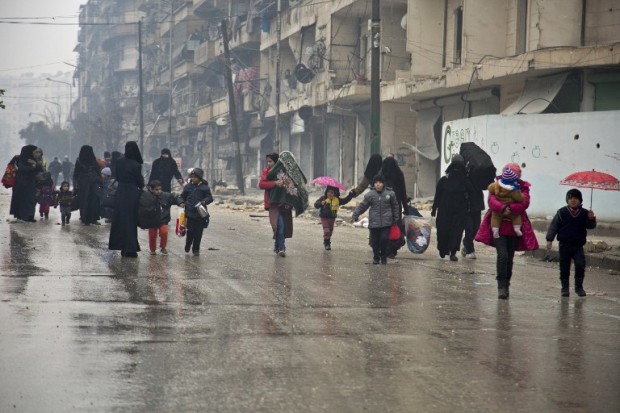 Syrians leave a rebel-held area of Aleppo towards the government-held side on December 13, 2016 during an operation by Syrian government forces to retake the embattled city. UN chief Ban Ki-moon expressed alarm over reports of atrocities against civilians Monday, as the battle for Aleppo entered its final phase with Syrian government forces on the verge of retaking rebel-held areas of the city.  / AFP PHOTO / KARAM AL-MASRI