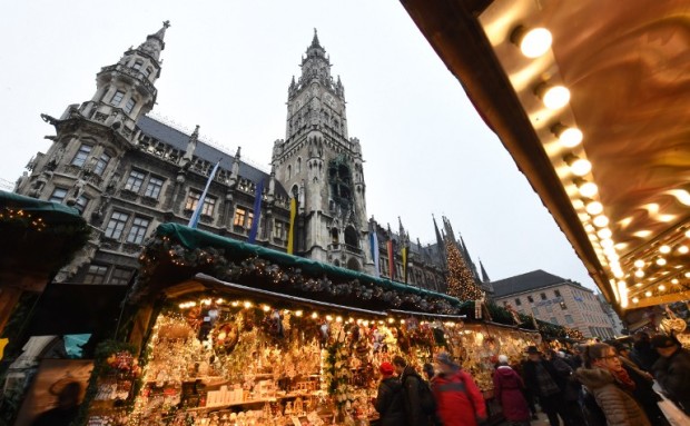 People walk between booths of the Christmas market in front of the city hall at the Marienplatz in Munich, southern Germany, on December 20, 2016, one day after a truck crashed into a Christmas market in Berlin.  / AFP PHOTO / Christof STACHE