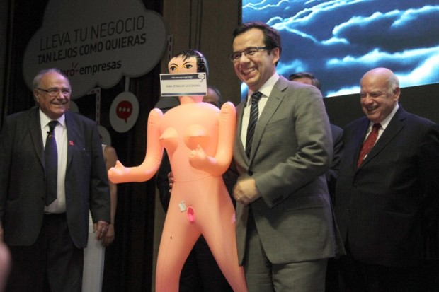 Chile's Economy Minister, Luis Felipe Cespedes (C), receives an inflatable doll from the president of the Association of Exporters and Manufactures (Asexma) Roberto Fantuzzi (L) during a Chistmas dinner of the export union in Santiago, on December 13, 2016. Chilean political and social sectors reacted on December 14, 2016, with a lot of reproaches against the business leader who at the time of making his particular gift, compared women with the economy, pointing out that both should be 'stimulated' for being activated. A sticker on the face of the gift doll reads 'To Stimulate the Economy.' / AFP PHOTO / George CADENAS