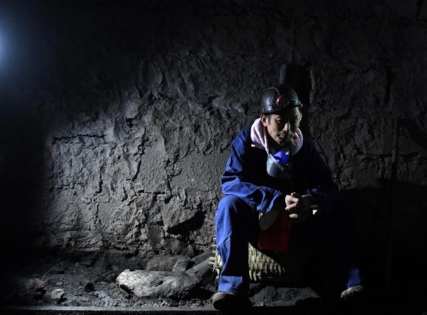 This photo taken on October 31, 2016 shows a rescuer waiting at the pithead of Jinshangou Coal Mine in Yongchuan District of Chongqing. All 33 miners missing after a colliery explosion in China earlier this week have been confirmed dead, state media reported on November 2, in the country's latest mining accident. / AFP PHOTO / STRINGER / China OUT
