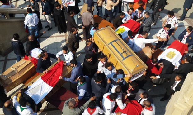 Egyptian clergymen and officials carry the coffins of the victims of a bomb explosion that targeted a Coptic Orthodox Church the previous day in Cairo, at the end their funeral in the capital's Nasr City neighbourhood on December 12, 2016. / AFP PHOTO / Khaled DESOUKI